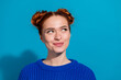 © deagreez - Young woman with trendy hairstyle smiling in front of bright blue background, wearing a casual knitted sweater