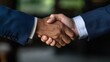 © Nana - Close up Handshake Two Men in Navy Suits Shake Hands Against a Blurred Background