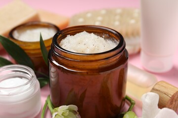Wall Mural - body care products, flowers and leaves on pink background, closeup