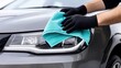 © Newleks - Professional detailer cleaning gray car headlight, wearing black gloves and using microfiber cloth for precise, spotless automotive detailing