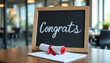 © AlenaSi - Congrats message on chalkboard with diploma on wooden table