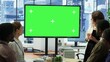 © DC Studio - Diverse group of startup employees looking at green screen on an interactive board, meeting to discuss ideas and details to ensure organizational progress. Forecast affiliates in office. Camera A.