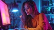 © sarayut - Young Woman in Orange Sweater Working on Computer at Night with Neon Pink and Blue Lighting