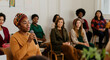 © Postmodern Studio - African female adult speaks in diverse adult group meeting