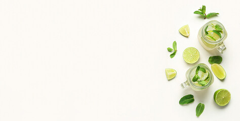 Wall Mural - Mason jars of tasty mojito and ingredients on light background
