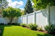 © miss irine - White vinyl fence installation wraps backyard. Exterior home property barrier ensures privacy, security. Boundary landscaping hard-wearing, modern, stylish for residential garden, protection,