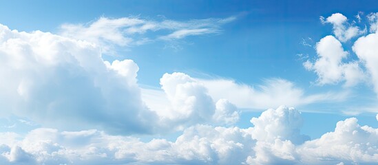 Poster - Expansive blue sky adorned with fluffy white clouds creating a serene and picturesque atmosphere with soft gradients of blue and white.