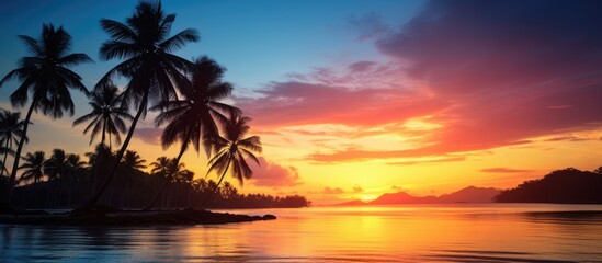 Poster - Serene sunset over a tropical island with vivid orange and purple hues, silhouetted coconut palms along the horizon reflecting on calm waters