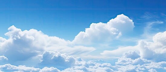 Poster - Expansive azure sky adorned with fluffy white clouds creating a serene and tranquil ambiance ideal for copy space and artistic designs
