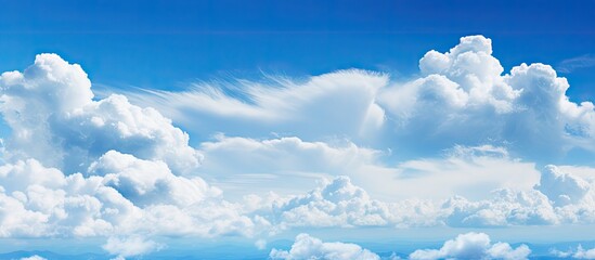 Poster - Vast blue sky with fluffy white clouds creating a serene copy space in the upper area, bright and clear atmosphere for diverse uses