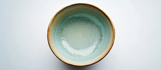 Poster - Top view of a ceramic bowl featuring a light green interior and a light brown rim against a clean white background, highlighting intricate patterns.