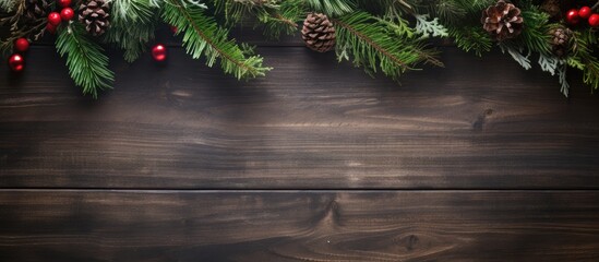 Poster - Christmas background with fir branches, pine cones, and red berries on dark wooden surface, featuring ample top copy space for text.
