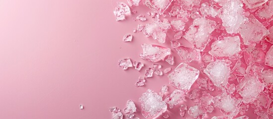 Leinwandbilder - Crushed ice scattered across a soft pink backdrop with empty space for text on the right side creating a fresh and cool aesthetic.