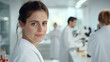 © ArtSync Studio - Confident Female Scientist in Laboratory Environment Smiling Portrait and Colleagues at Work