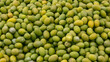 © Artem - Background of green olives with smooth shiny surfaces natural shades of yellow and light green create a vibrant and organic texture