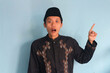 © Lailar Studio - Shocked face of young Asian Muslim man while pointing finger up