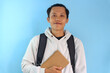 © Lailar Studio - Asian male student smiling while holding notebook