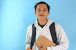 © Lailar Studio - Asian male student smiling while holding notebook