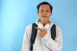 © Lailar Studio - Asian male student smiling pointing to the side. wearing a black bag.
