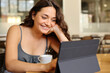 © Antonioguillem - Happy woman using digital tablet in a restaurant