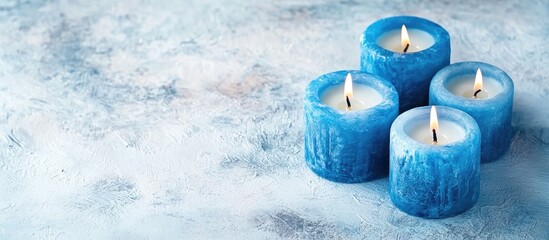 Poster - Blue candles with flickering flames arranged in a cluster on a soft textured white background featuring cool tones and subtle depth for serene ambiance.