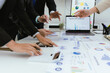 © Witoon - A team of professionals work together in an office to analyze financial charts, market strategies and work as a team to drive business growth and success.