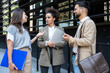 © Srdjan - Brainstorming. Group of young innovative business people, businessman and businesswoman standing out of office building, preparing for presentation at staff meeting with corporation management.