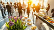 © ABF_MATEO - Indoor gathering with people socializing around tables of food and a flower centerpiece, bathed in sunlight. Social Event.