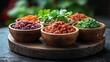 © Kipli - Assorted colorful dips in wooden bowls on a dark surface.