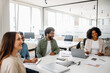 © Vadim Pastuh - A business team enjoys a lighthearted moment during a meeting in a bright office. The diverse group fosters a collaborative and friendly work atmosphere
