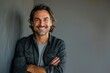 © Markus Schröder - Portrait of a glad man in his 30s with arms crossed isolated on soft gray background