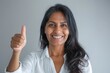 © Markus Schröder - Portrait of a jovial indian woman in her 40s showing a thumb up over soft gray background