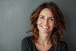 © Markus Schröder - Portrait of a happy caucasian woman in her 40s smiling at the camera in soft gray background