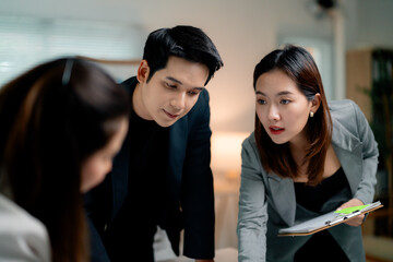 Poster - Asian businesspeople analyzing documents and working together on a project in the office