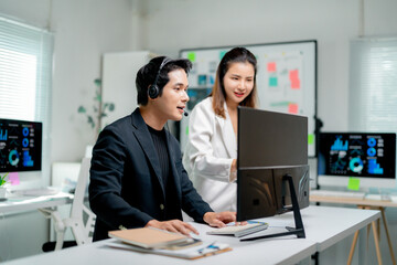 Poster - Two Asian businesspeople discussing marketing data on computer screen, working together in office