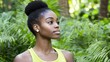 © imagineRbc - A young woman with natural hair is seen wearing a bright tank top while surrounded by vibrant green plants, displaying a sense of tranquility and connection to nature in daylight