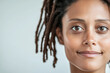 © Chari - Woman with dreadlocks displaying a warm smile in a minimalist setting