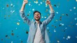© AndreyFrol - A portrait of a satisfied young man who happily raises his hands up against the backdrop of falling or flying golden confetti. A man expresses delight and happiness