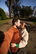 © asier - Romantic tourists kissing, capturing selfie moment near traditional horreos in combarro's winter sunlight, galician coastal landscape