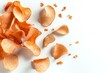 © Yuliia - Scattered orange potato chips on white background, crispy curved snack pieces with natural texture and shadows, isolated food composition for packaging design.
