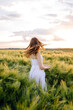 © DSMT - A Serene Woman in a Beautiful White Dress Elegantly Dancing in a Sunlit Open Field