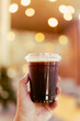 © Dontree - The hand holding a cup of cold Americano in coffee shop.