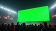 © BlackCat - A giant LED screen in a packed sports stadium at night, displaying a bright green screen for chroma key effects. The stadium is illuminated by powerful floodlights, and the energetic crowd waves banne