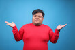 © Gatot - Portrait of Young Asian Fat Guy Showing Shrugging Hands Gesture Isolated on Blue Background