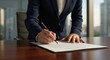 © Chantelle - A businesswoman signs a contract with a fountain pen in a modern office.