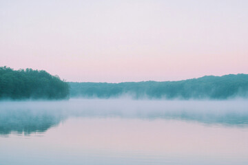Wall Mural - Serene lake at dawn with a gentle mist rising from the calm waters and lush green forests in the distance, under a pastel pink sky.