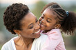 © GTNA73 - Happy afro-american mother carrying smiling hugs daughter in her arm. Closeup.