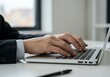 © MD NAZMUL - Businessperson Typing on Laptop in Modern Office