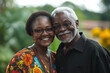© kristina - Older couple smiling and posing for photo in a park.