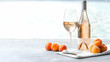 © julio - Glass Of Refreshing Rose Wine With Apricots And Bottle On Table Seaside Relaxation During Summer Vacation With Bright Lighting